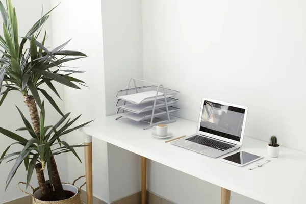 Mesa de oficina en la que portátil, café, tableta, cámara y otros artículos — Foto de Stock