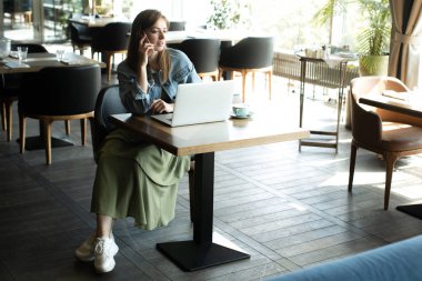 Genç kız kahve içme ve telefonda konuşmak