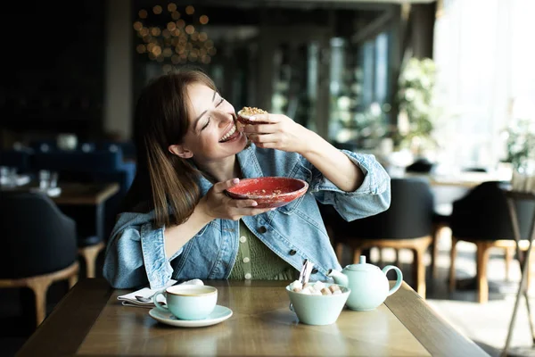 Молодая девушка пьет чай с десертом — стоковое фото