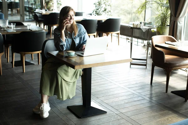 Jong meisje drinken koffie en praten over de telefoon — Stockfoto