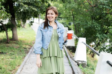 Genç kız sokakta kahve içme ve yürüyüş