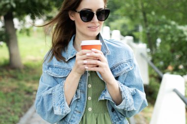 Genç kız sokakta kahve içme ve yürüyüş