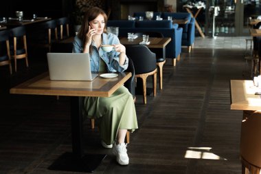 Genç kız kahve içme ve telefonda konuşmak