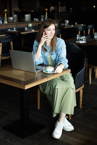 Genç kız kahve içme ve telefonda konuşmak