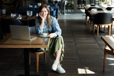 Genç kız kahve içme ve telefonda konuşmak