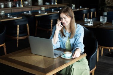 Genç kız kahve içme ve telefonda konuşmak