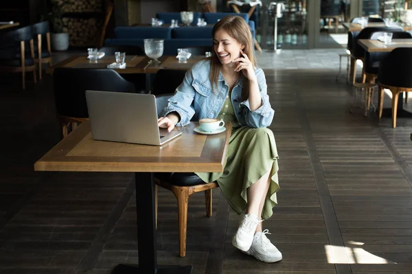 Молодая девушка пьет кофе и разговаривает по телефону — стоковое фото
