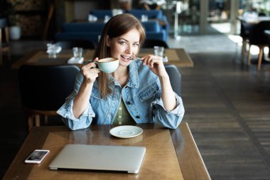 Genç kız kahve içme ve telefonda konuşmak