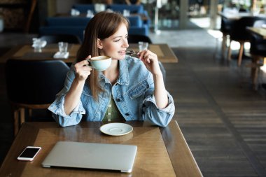 Genç kız kahve içme ve telefonda konuşmak
