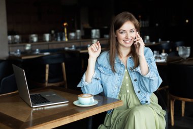 Genç kız kahve içme ve telefonda konuşmak