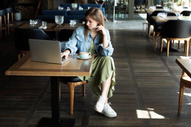 Genç kız kahve içme ve telefonda konuşmak