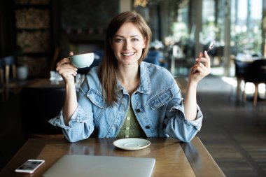 Genç kız gülümseyen ve bir kahve içme