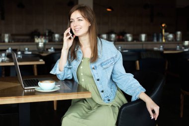 Genç kız kahve içme ve telefonda konuşmak