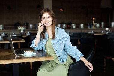 Genç kız kahve içme ve telefonda konuşmak