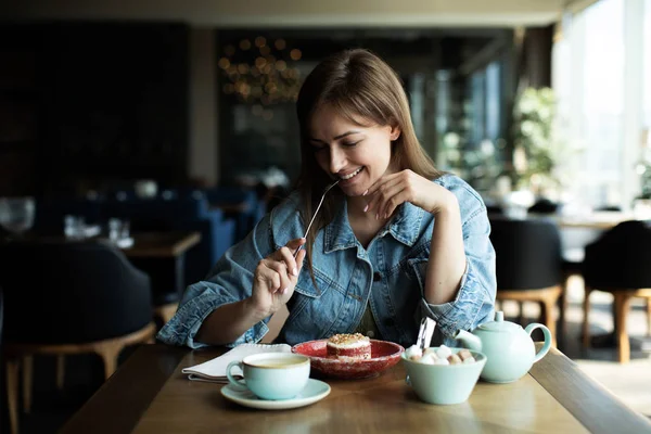 Молодая девушка пьет чай с десертом — стоковое фото