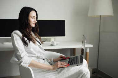 parlak bir ofiste bir laptop üzerinde çalışan kız