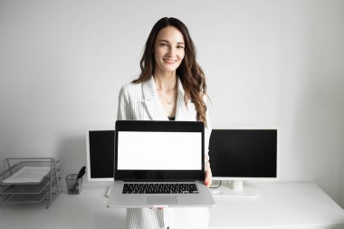 bir laptop tutan ofiste kız