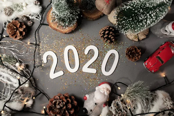 Feliz Año Nuevo 2020. Símbolo del número 2020 sobre fondo gris con juguetes de Navidad — Foto de Stock