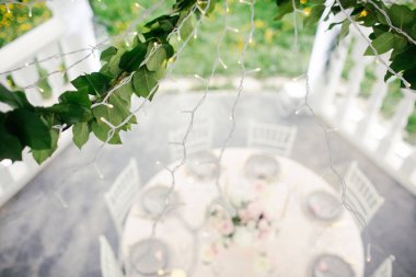 Düğün yemeği için ahşap masalarda çiçekler olan inanılmaz bir düğün masası süsü.