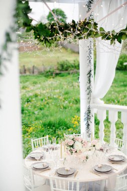 Düğün yemeği için ahşap masalarda çiçekler olan inanılmaz bir düğün masası süsü.