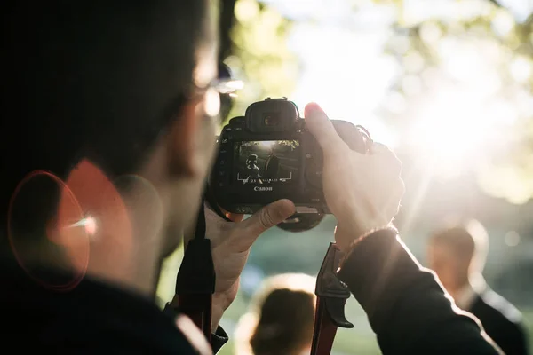 Moscow, The Russia - June 13, 2017: a young photographer shoots a beautiful couple at sunset on a canon camera — Stock Photo, Image