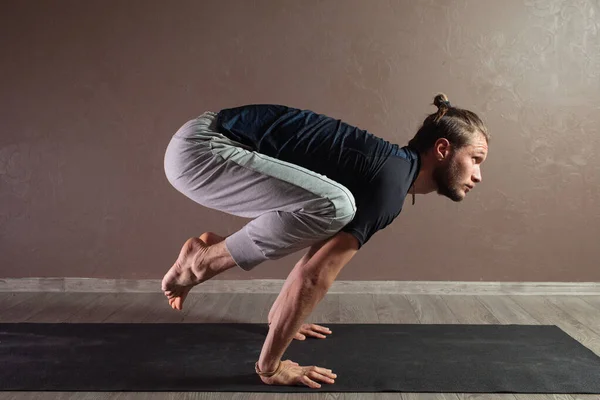 Jovem homem esportivo praticando ioga, meditando em Half Lotus pose, exercitando-se, vestindo sportswear, comprimento total interior, estúdio de ioga marrom — Fotografia de Stock
