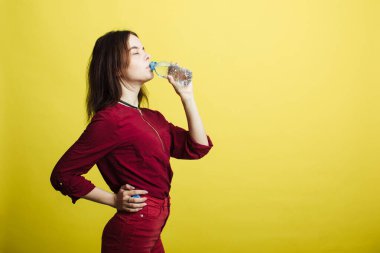 Sarı arka planda tek başına duran mutlu genç kız görüntüsü.