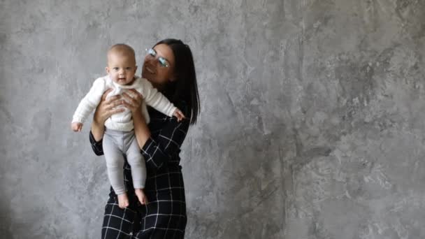 Hermosa joven madre jugando con su adorable hija. Mamá mira desde diferentes lados y besa a su hija. Riendo, momentos felices . — Vídeo de stock