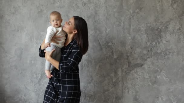 Mooie jonge moeder die speelt met haar schattige dochter. Mam kijkt uit van verschillende kanten en kust haar dochter. Lachende, gelukkige momenten. — Stockvideo