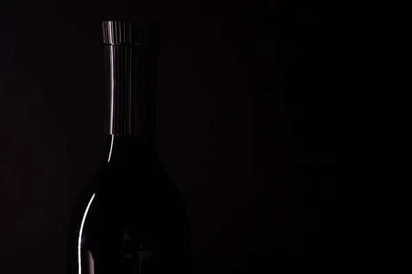 Empty bottle on black background. Bottle silhouette
