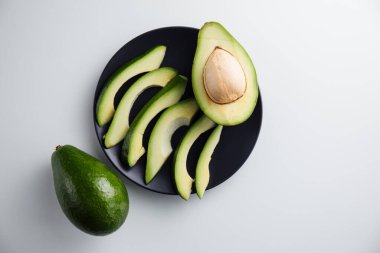 Avokado tabakta ve beyaz arka planda. En küçük konsept