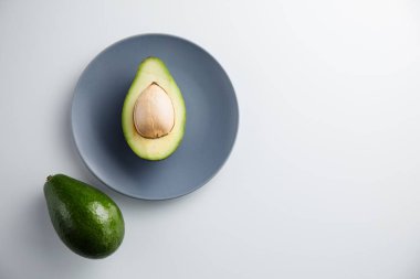 Avokado tabakta ve beyaz arka planda. En küçük konsept