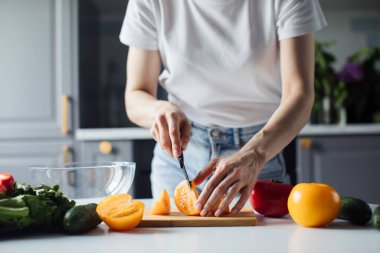 Salata için sebze kesen bir kızın ellerine yakın çekim. Sağlıklı yemek.