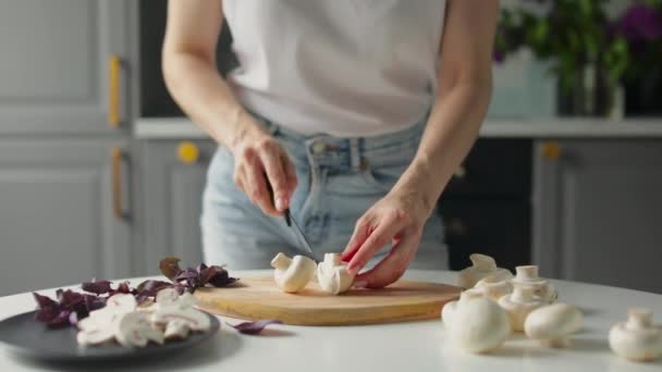 Flickan skär grönsaker i ett ljust kök. Hälsosam mat. — Stockvideo
