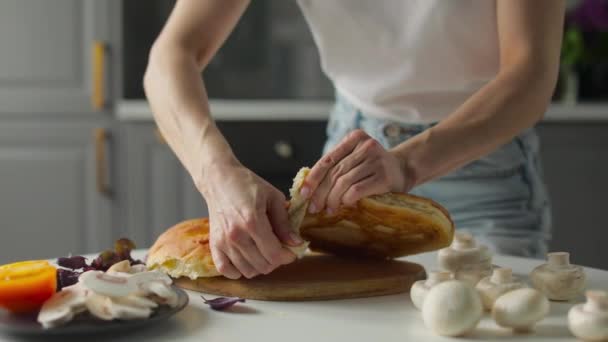 Dívka láme chleba s rukama v jasné kuchyni. Zdravé jídlo. — Stock video