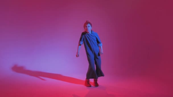 Menina elegante jovem dançando no estúdio em um fundo de néon colorido. Design de cartaz dj música . — Vídeo de Stock