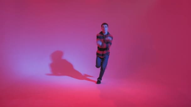 젊은 남자가 스튜디오에서 점퍼 댄싱 컨템포러리 댄스를 추는 모습. 브레이크 댄스. 댄스 스쿨 포스터. 복사 우주. 전투 대회 발표. 핑크와 푸른 배경. — 비디오