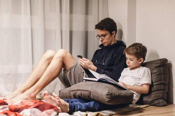 父子俩在舒适的房间里看书 — 图库照片