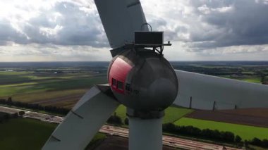 Rüzgar türbini, temiz enerji, Hollanda kırsalında yenilenen enerji. Rüzgardan gelen elektrik, yakın görüş. Bıçaklar, mavi gökyüzü, yeşil alanlar. 60 fps sonra hava görüntüsü.