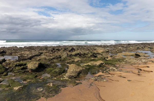 低潮帯の岩のビーチの波と青い曇り空シースケープ ダーバン 南アフリカ共和国に対して海 — ストック写真