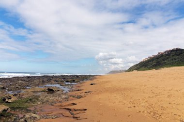Düşük tide kayalık plaj dalgalar ve okyanus mavi bulutlu gökyüzü deniz manzarası Garvies Beach, karşı blöf, Durban, Güney Afrika