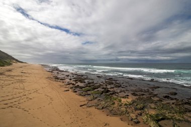 Düşük tide kayalık plaj dalgalar ve okyanus mavi bulutlu gökyüzü deniz manzarası Garvies Beach, karşı blöf, Durban, Güney Afrika