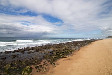 Düşük tide kayalık plaj dalgalar ve okyanus mavi bulutlu gökyüzü deniz manzarası Garvies Beach, karşı blöf, Durban, Güney Afrika