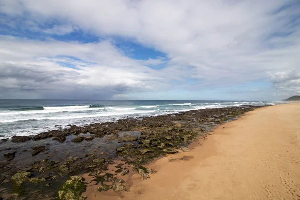 Düşük tide kayalık plaj dalgalar ve okyanus mavi bulutlu gökyüzü deniz manzarası Garvies Beach, karşı blöf, Durban, Güney Afrika