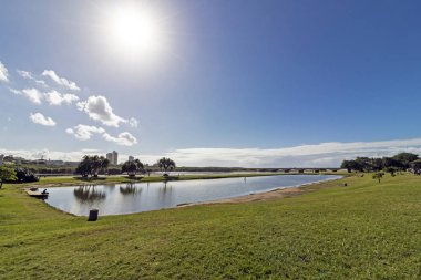 Blue Lagoon Haliç güneş ve mavi bulutlu kıyı manzarası Durban Güney Afrika'da karşı yeşil çim görünümünü sabah
