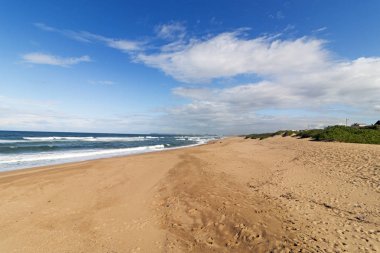 Beach okyanus mavisi bulutlu gökyüzü ve uzak şehir silüeti manzarası Durban, Güney Afrika