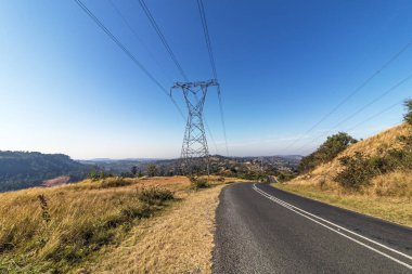 Durban, Güney Afrika genel gider pilon ve powerlines uzak kırsal ilçe ve Shongweni mavi gökyüzüne doğru asfalt yol başlığının yanındaki oteller