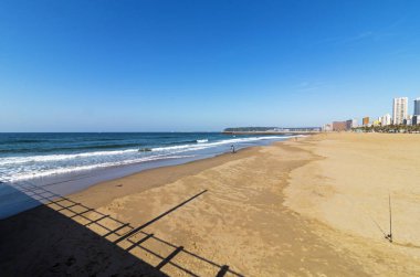 Mavi okyanus su ile uzak mesafe binalarda giden sahil kumu firsfside görünümünü 