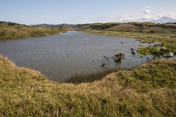 Floden omgiven av Grassy Banks och Hills — Stockfoto