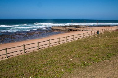 Çimen yolu ile kumsal arasında gelgit havuzlu ahşap çit